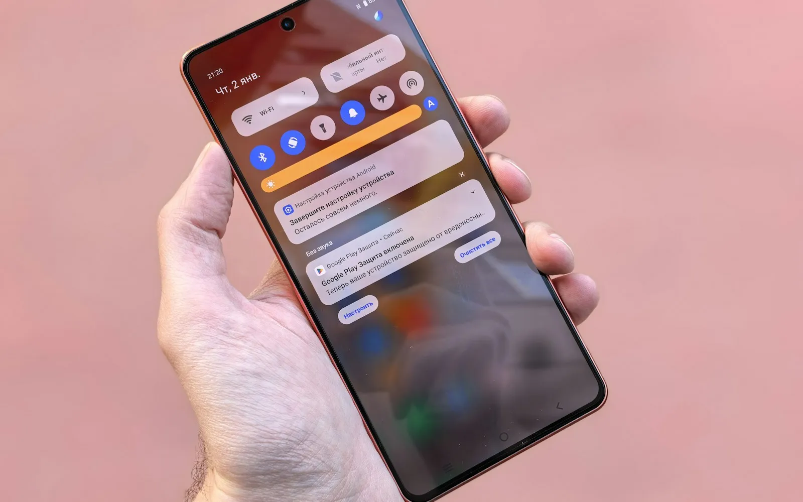 Hand holding a smartphone with a stack of notifications on the lock screen